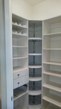 an empty pantry with white shelves and drawers