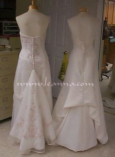 two wedding gowns are on display in a room