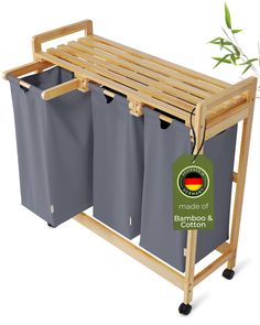 a bamboo shelf with three grey trash cans