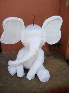 an elephant made out of toilet paper sitting on the ground