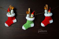 crocheted christmas stockings hanging on a clothes line with bells and bells attached to them