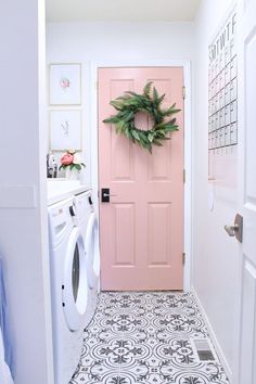 a washer and dryer are in front of a door with a wreath on it