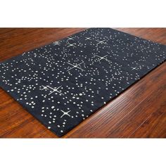 a black and white area rug with stars on the floor in front of a wooden floor