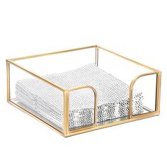 a clear and gold desk caddy with two compartments on each side, one holding a napkin