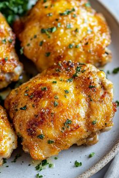 a white plate topped with chicken wings covered in parmesan cheese and garnish