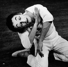 black and white photograph of a man on the ground with his head in his hands