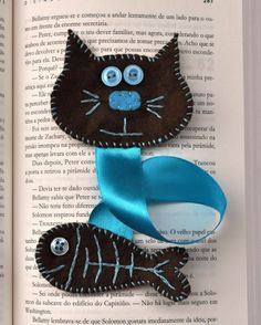 an open book with two black cats on it and a blue ribbon around the eyes