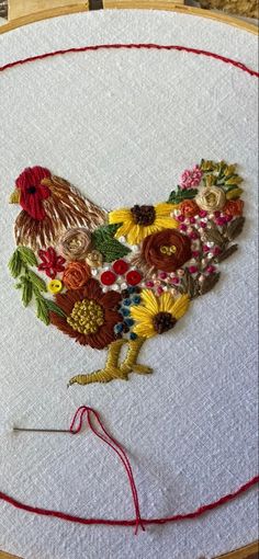 a close up of a embroidery on a piece of cloth with a rooster in the center