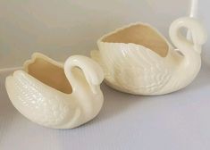 two white swan shaped vases sitting next to each other