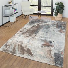 a living room area with a rug, chair and window in the background that has an abstract painting on it