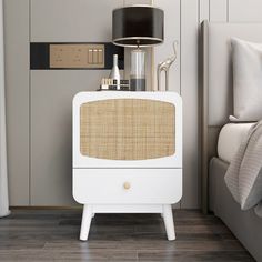 a white bedside table with a lamp on top