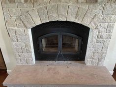 a stone fireplace with a black fire place