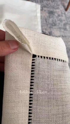 someone is stitching the side of a piece of fabric