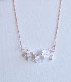 a necklace with white flowers and pearls on it