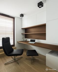 a chair and ottoman sit in front of a desk with a laptop computer on it