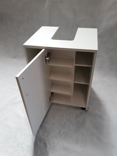 an empty white cabinet with shelves on the bottom and one door open to reveal it's contents