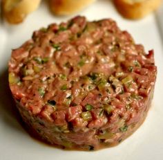 a steak tartare on a white plate with text overlay that reads classic steak tartare beef tartare