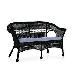 a black wicker couch with blue cushions on it's back end and armrests