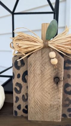 a wooden block with a green leaf and some beads on it sitting on a table