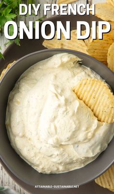 a bowl full of dip with chips on the side