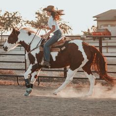 a woman riding on the back of a brown and white horse