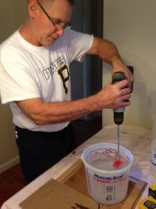 a man is using a drill to paint the wall