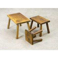 two wooden stools sitting next to each other on a white floor with no one around them