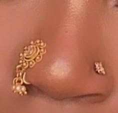 the nose is adorned with gold jewelry