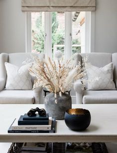 a living room filled with furniture and a white coffee table in front of a window