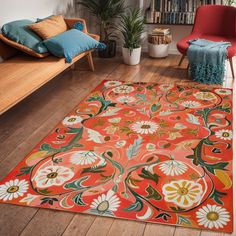 an orange rug with flowers on it in front of a couch and bookshelf