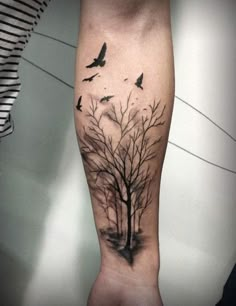 a tree with birds flying around it on the right arm and left leg tattoo design