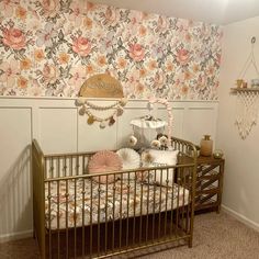 a baby crib in front of a floral wallpapered wall with flowers on it