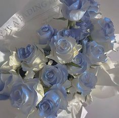 a bouquet of blue and white roses in a vase