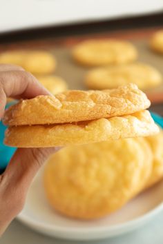 a person is holding up some cookies on a plate