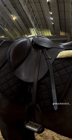 there is a black horse that has a saddle on it's back and bridle around its neck