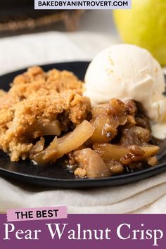 the best pear walnut crisp on a black plate with ice cream and an apple in the background