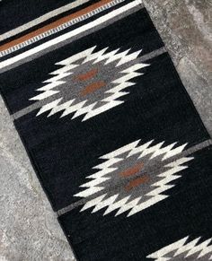 a black and white rug sitting on top of a stone floor