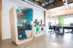 an office with a large mirror in the middle of it's wall and desks