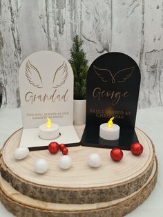 a couple of candles sitting on top of a wooden table next to a sign and tree