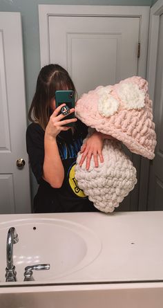 a woman taking a selfie in front of a bathroom mirror with her cell phone