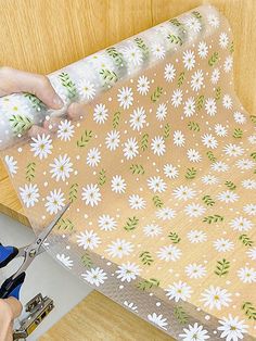 a person cutting fabric with scissors on a table