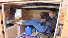 a woman sitting in a chair inside of a small cabin