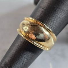 a gold wedding ring sitting on top of a black cloth