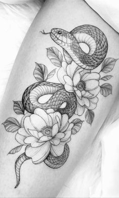 a snake and flowers tattoo on the thigh