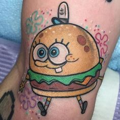 a cartoon character on the leg of a person with tattoos that look like hamburgers