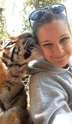 a woman in sunglasses is kissing a tiger with the caption, could use some ranch