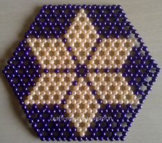 a beaded ornament that looks like a star on a white surface with blue beads