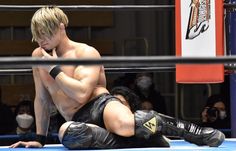 a shirtless man sitting on the ground next to a woman in a wrestling ring