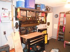 a garage with tools and other items on the shelves, including a workbench