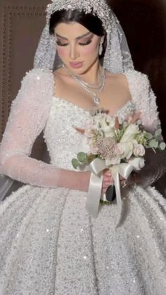 a woman in a white wedding dress holding a bouquet and wearing a tiara with flowers on it